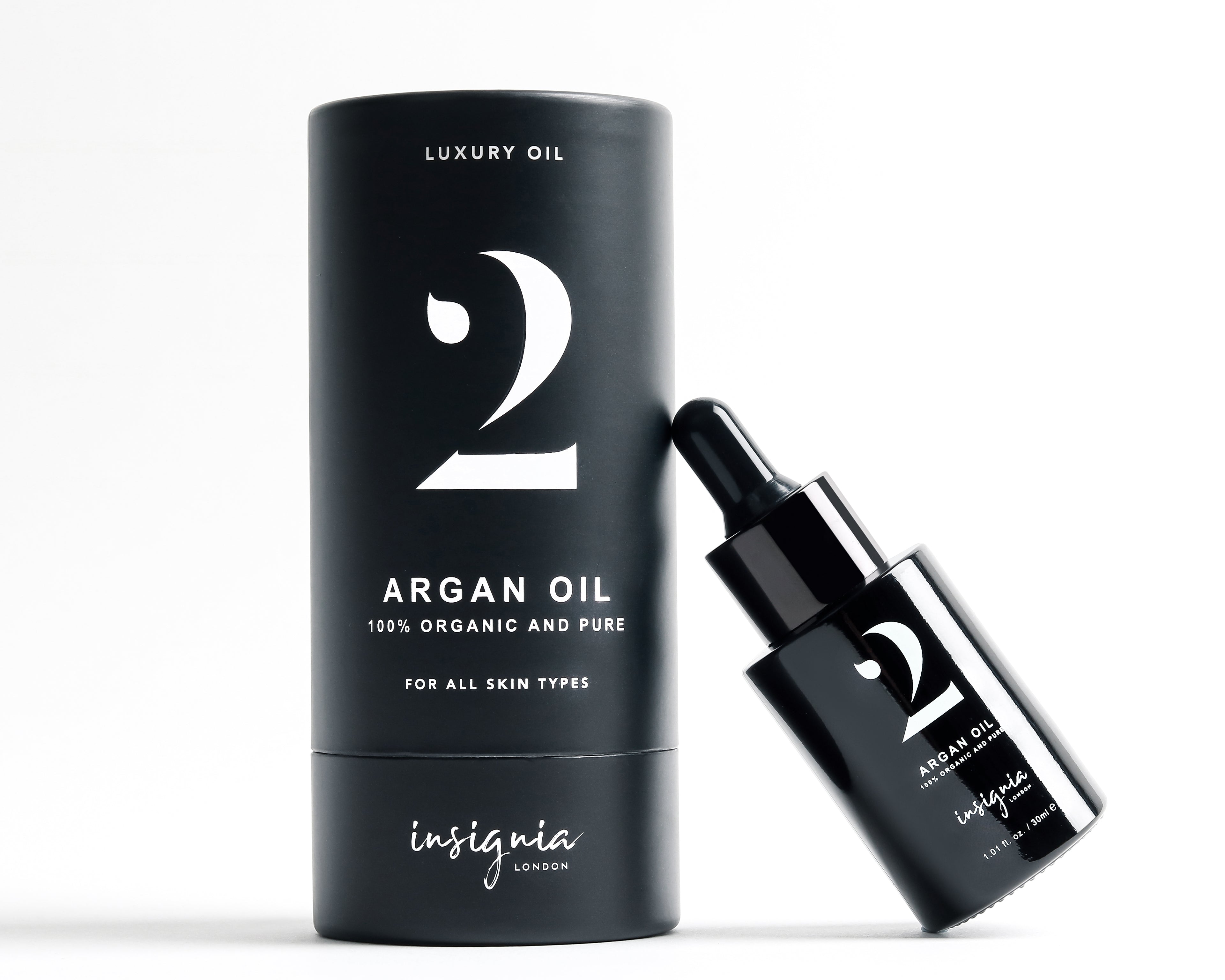 Insignia London No. 2 Luxury Argan Oil 30ml black glass bottle leaning against box on white background.