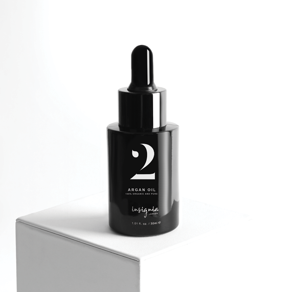 Insignia London No. 2 Luxury Argan Oil 30ml black glass dropper bottle displayed on white pedestal.